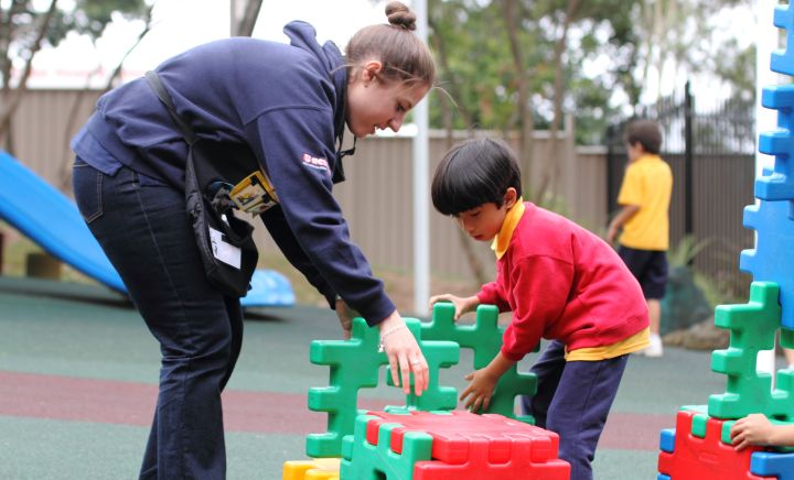 A teacher and student interact within the playground at Western Sydney School